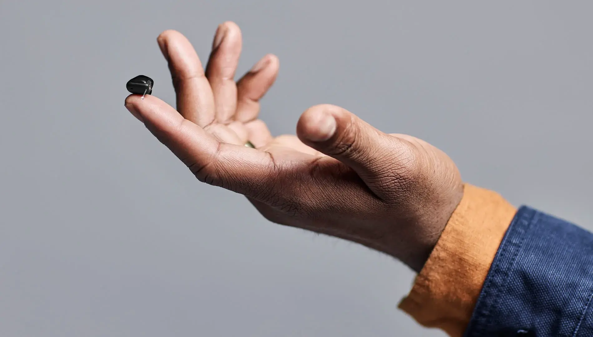 Custom CIC hearing aid on fingertip — invisible-fit demonstration