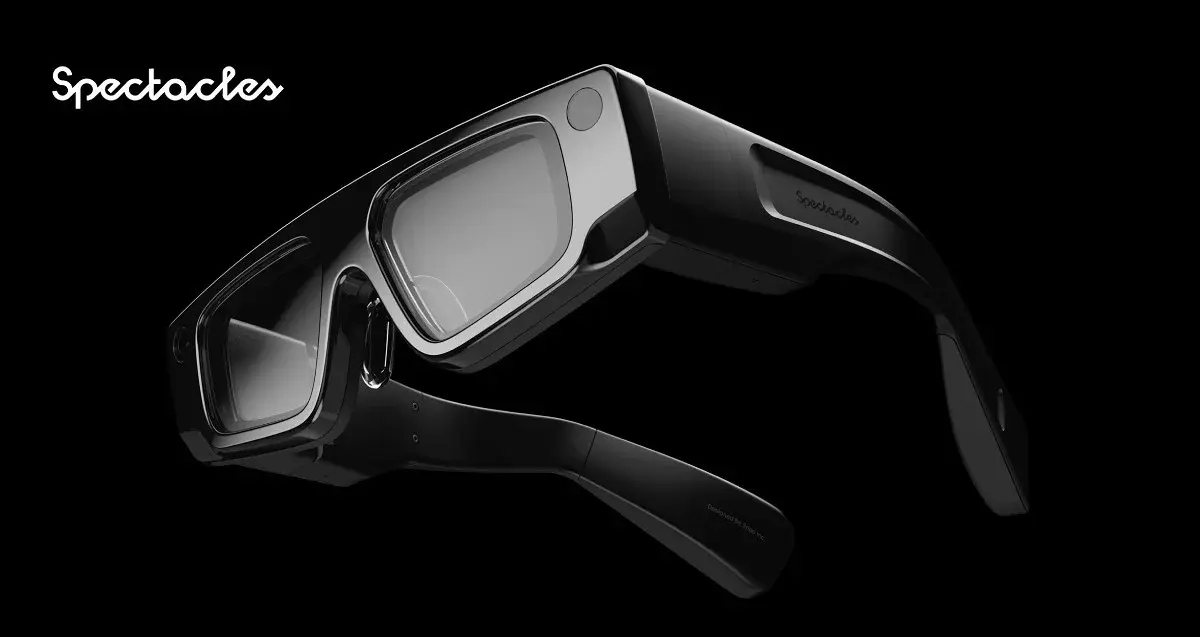 A pair of Snap Spectacles augmented reality glasses with a sleek black design are displayed against a black background.