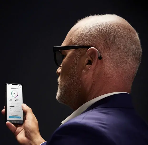 Adult wearing Starkey Evolv AI hearing aid — discreet behind-ear placement